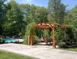 12’ x 17’ Hearthside Wooden Amish Pergola With Canyon Brown Stain, Superior Posts And Vines Surrounding Pergola