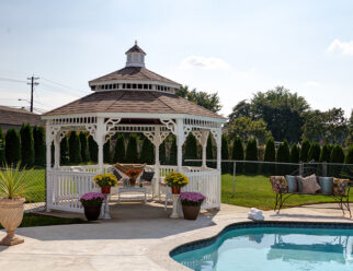 14' Octagonal Colonial Style White Vinyl Gazebo With Pagoda Style Roof And Black Shingles Next To Backyard Pool