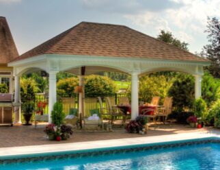 14’ x 20’ Traditional White Vinyl Pavilion with 10 inch Round Posts, Brown Asphalt Shingles In A Backyard Pool Patio
