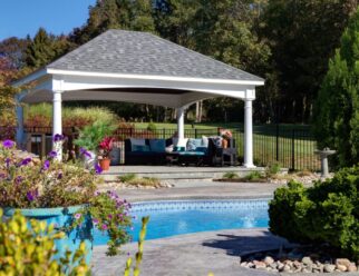 14’ x 20’ Traditional White Vinyl Pavilion with 10 inch Round Posts and Asphalt Shingles In A Backyard Pool Patio