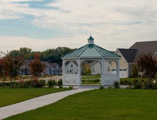 16′ Octagon, Country Style, White Vinyl Gazebo With Green Metal Roof In A Neighborhood Park