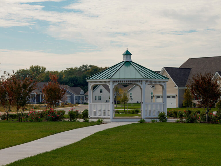 16′ Octagon, Country Style, White Vinyl Gazebo With Green Metal Roof In A Neighborhood Park