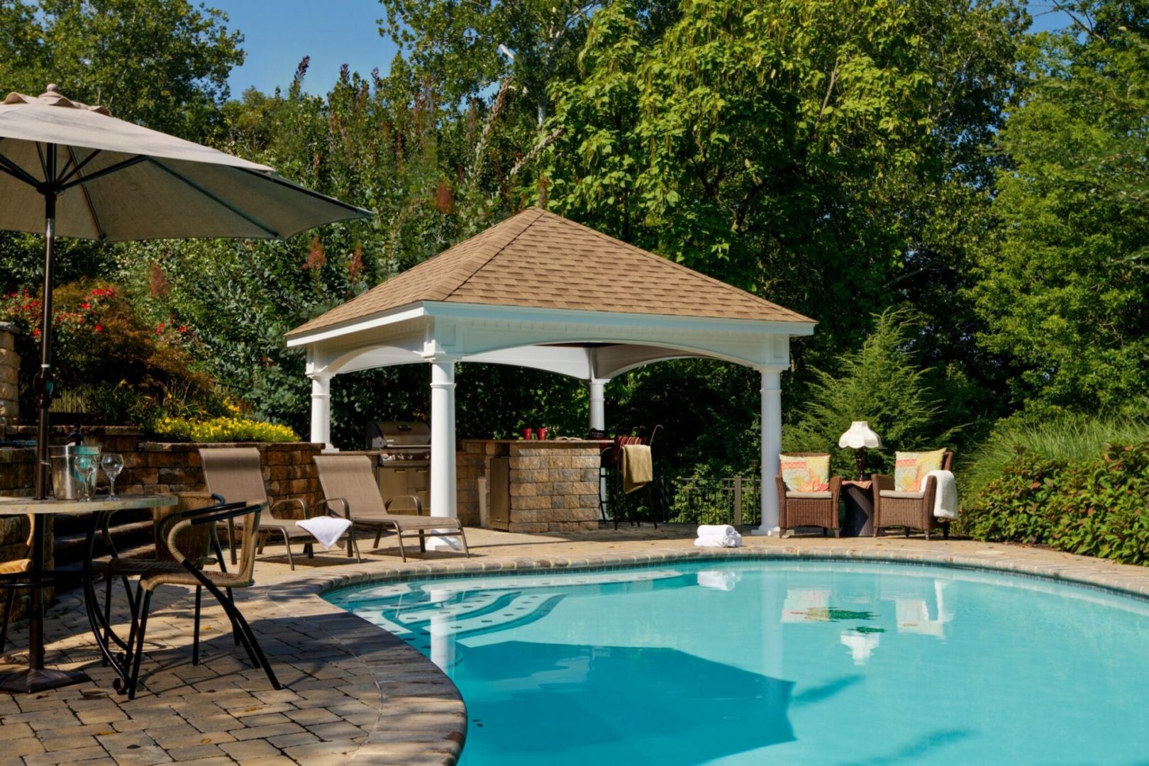 16’ x 16’ White Vinyl Hampton Pavilion With Brown Asphalt Shingles In A Backyard Pool Patio