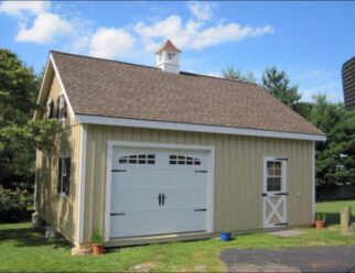 Beige Two Story Wooden Detached Garage With White Garage Door