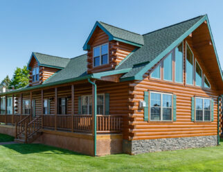 Side view of 28×52 Mountaineer Deluxe Cabin with Prow Roof, (2) 8' A-Frame Dormers, Log Corners, and 6-lite Signet Fir Entry Door with Stained Sidelites