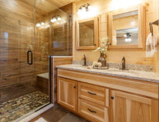 Mountaineer Deluxe Cabin Interior - Bathroom with Tile Shower, Frameless Glass Door, Quartz Vanity Top, and Bronze Faucets