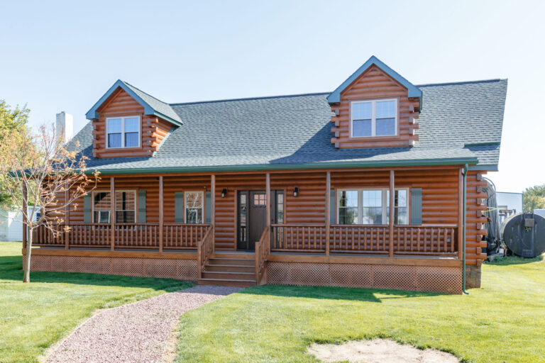 ront view of 28×52 Mountaineer Deluxe Cabin with Prow Roof, (2) 8' A-Frame Dormers, Log Corners, and 6-lite Signet Fir Entry Door with Stained Sidelites