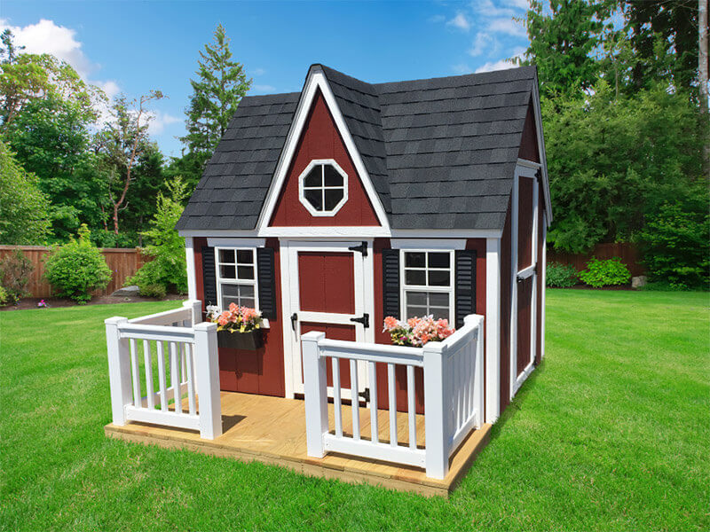 Red playhouse in fenced backyard