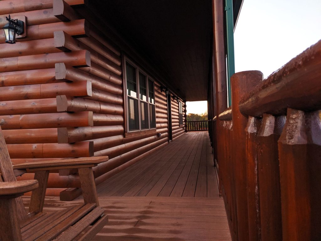 A shot showing the wrap around porch of an Amish-built log cabin.
