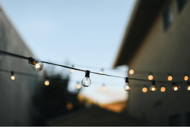 A picture of lights strung in a backyard.