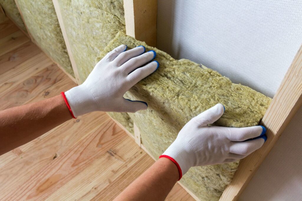 Installing insulation into shed walls.