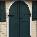 Green arched door with white trim