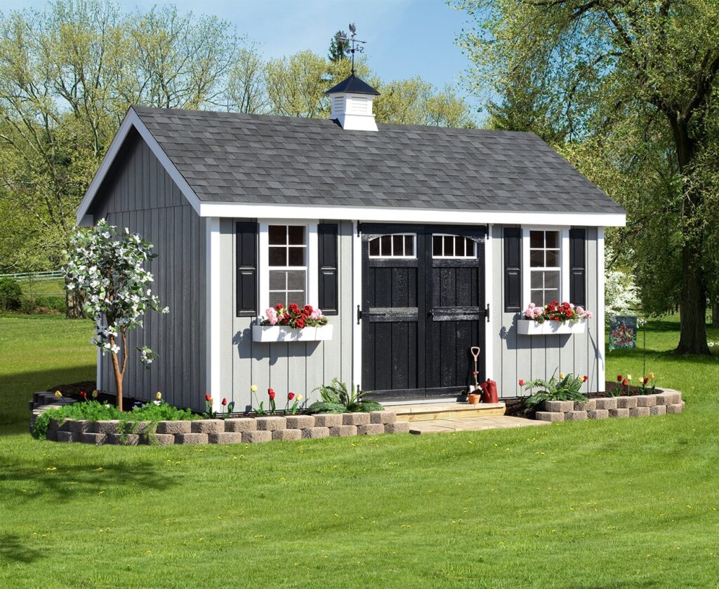 an a-frame shed with a small garden surrounding it. 