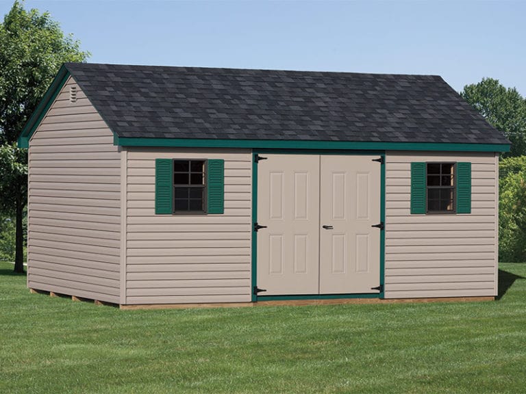 a cape shed with green trim and shutters.