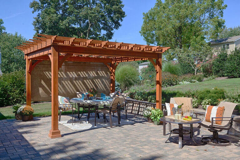 A wooden pergola on a patio with a privacy screen pulled down