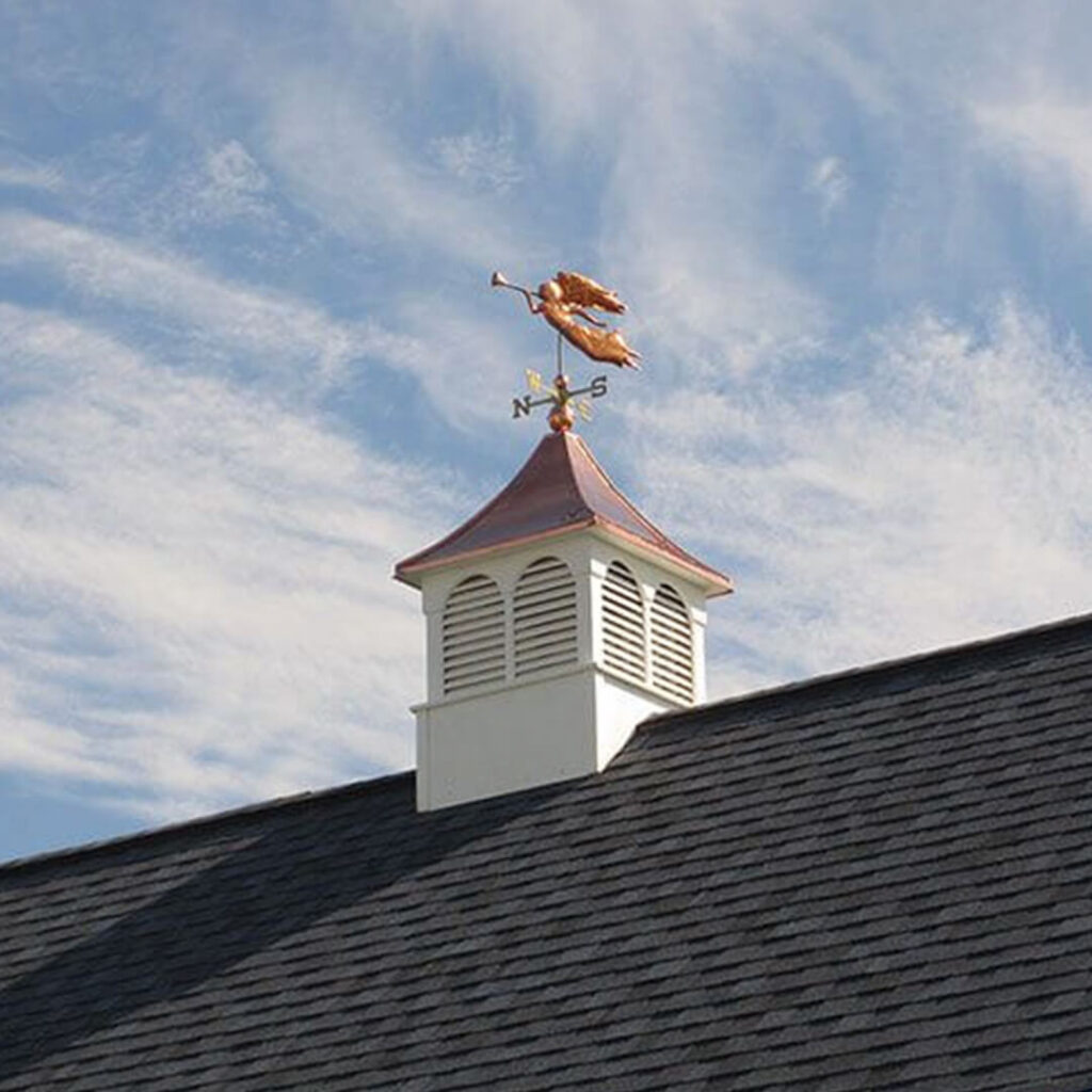 A shed roof with a cupola and weathervane on top