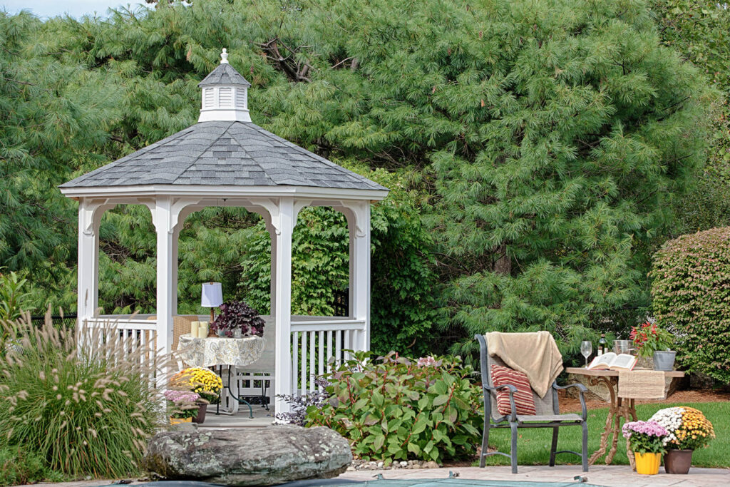White octagon vinyl gazebo on a patio with outdoor seating inside