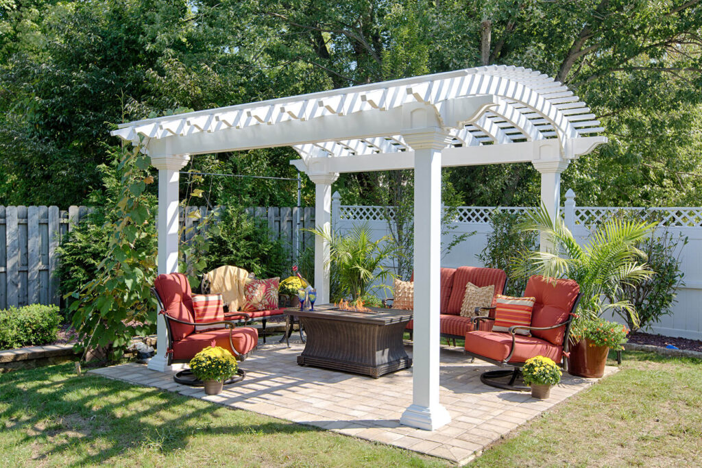 White vinyla pargola with an arched top and outdoor seating beneath