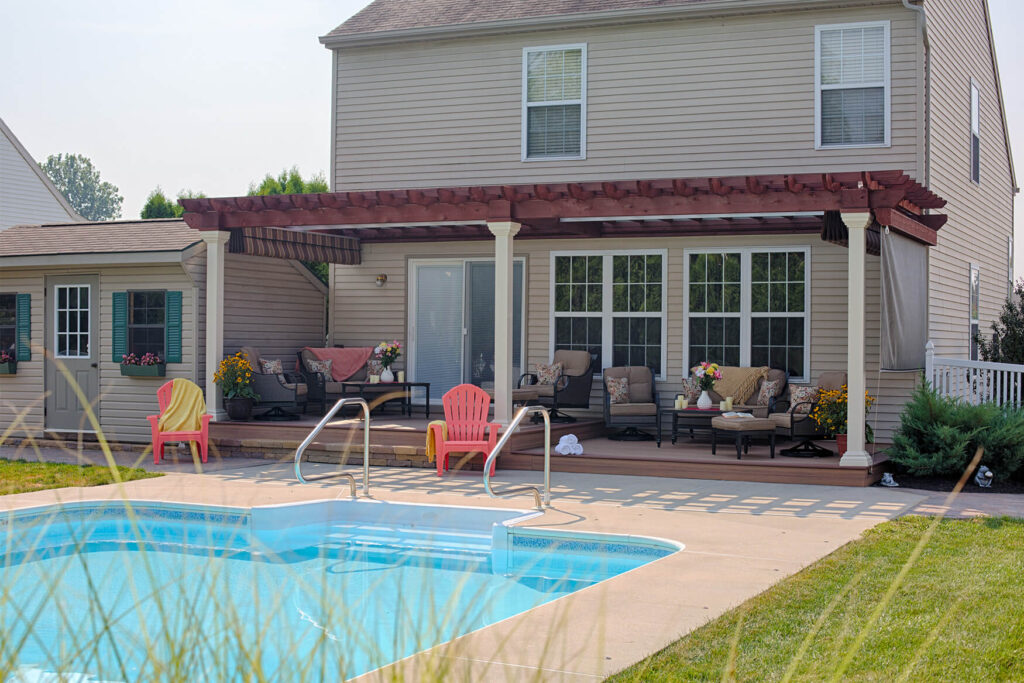 Wooden pergola attached to a house next to a pool