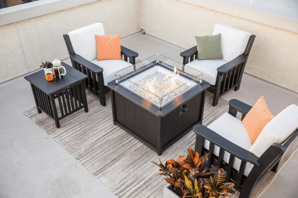 three patio furniture chairs around a fire pit on a balcony