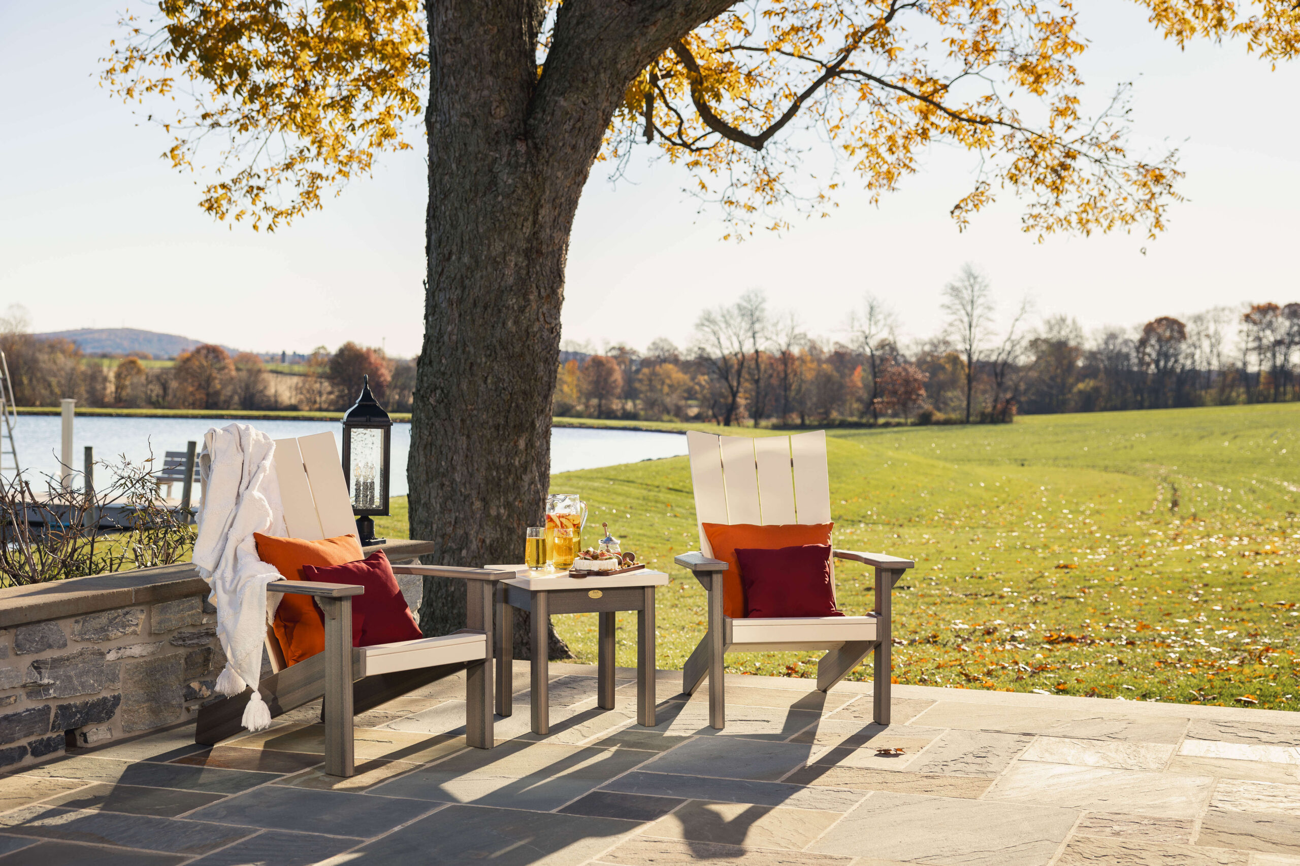 two patio furniture chairs and a side table with drinks on it