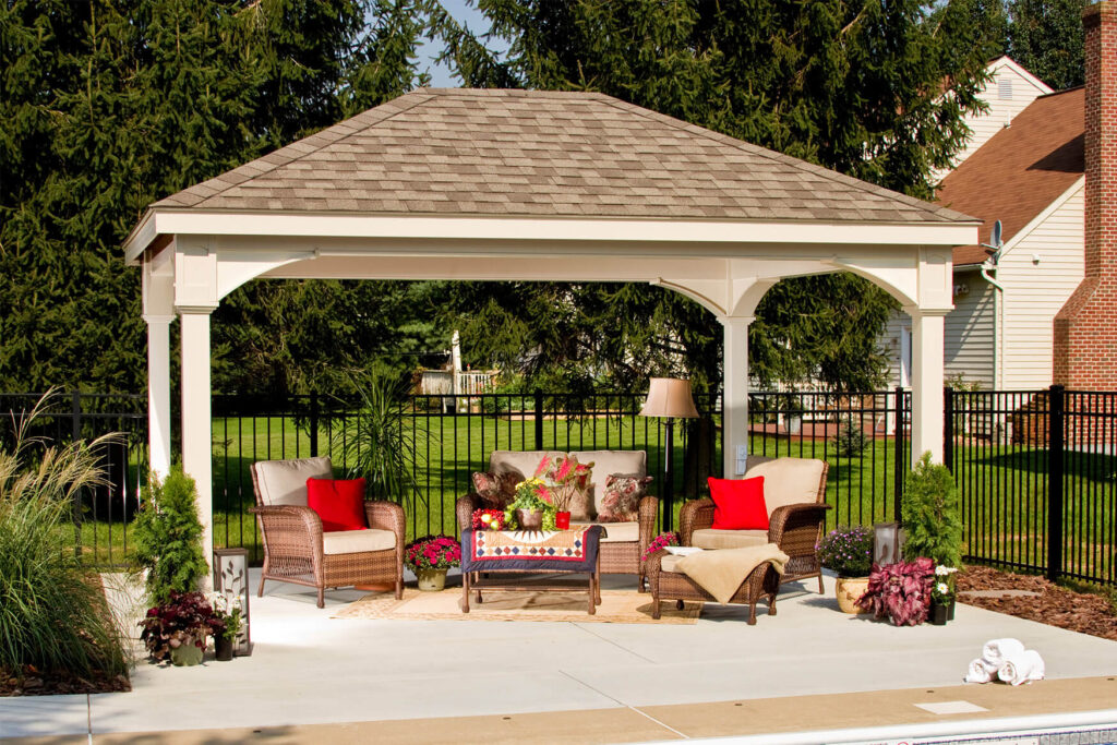A white pavilion with a set of patio furniture under it