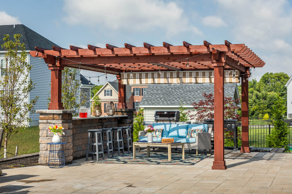 a wooden pergola with a set of patio furniture under it