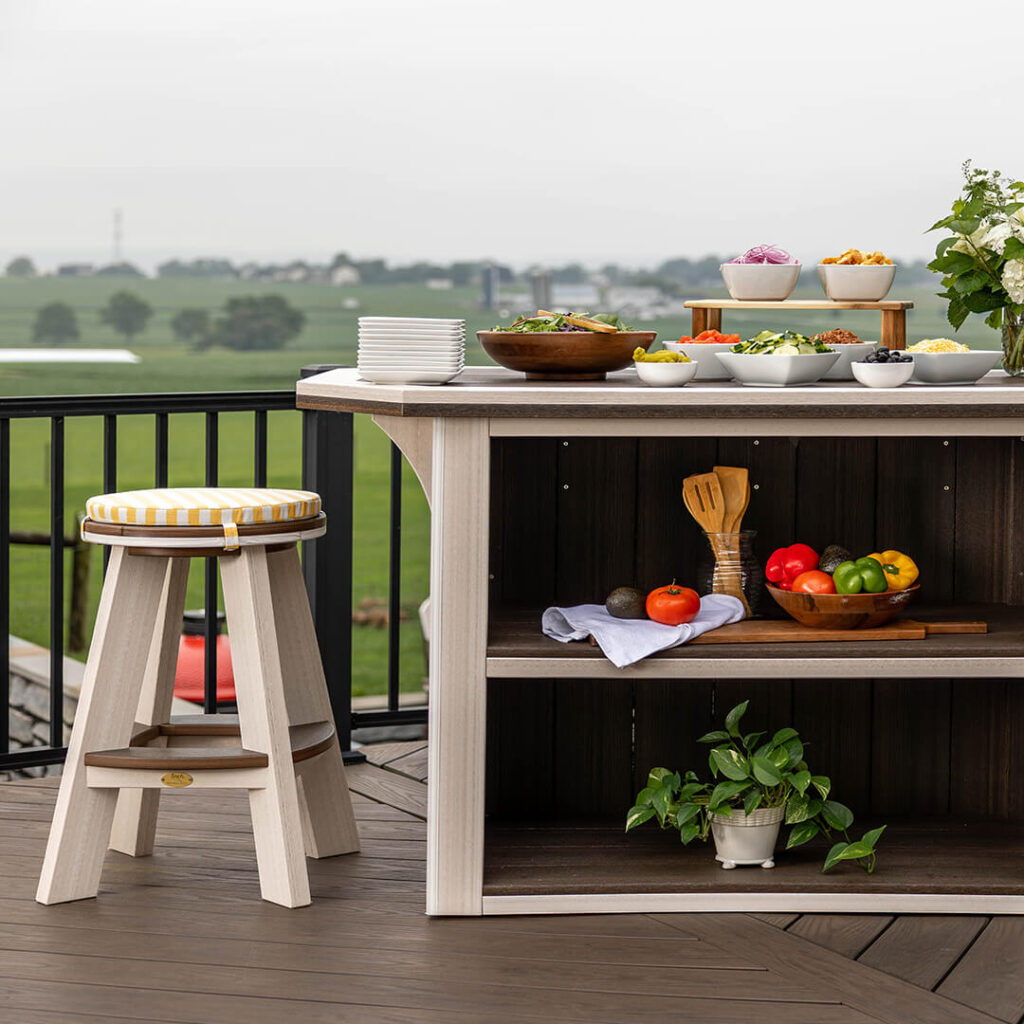 A bar and stool on a patio overlooking a field