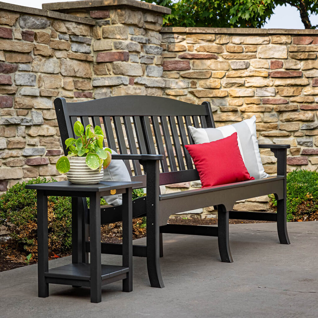 A black outdoor bench with a side table