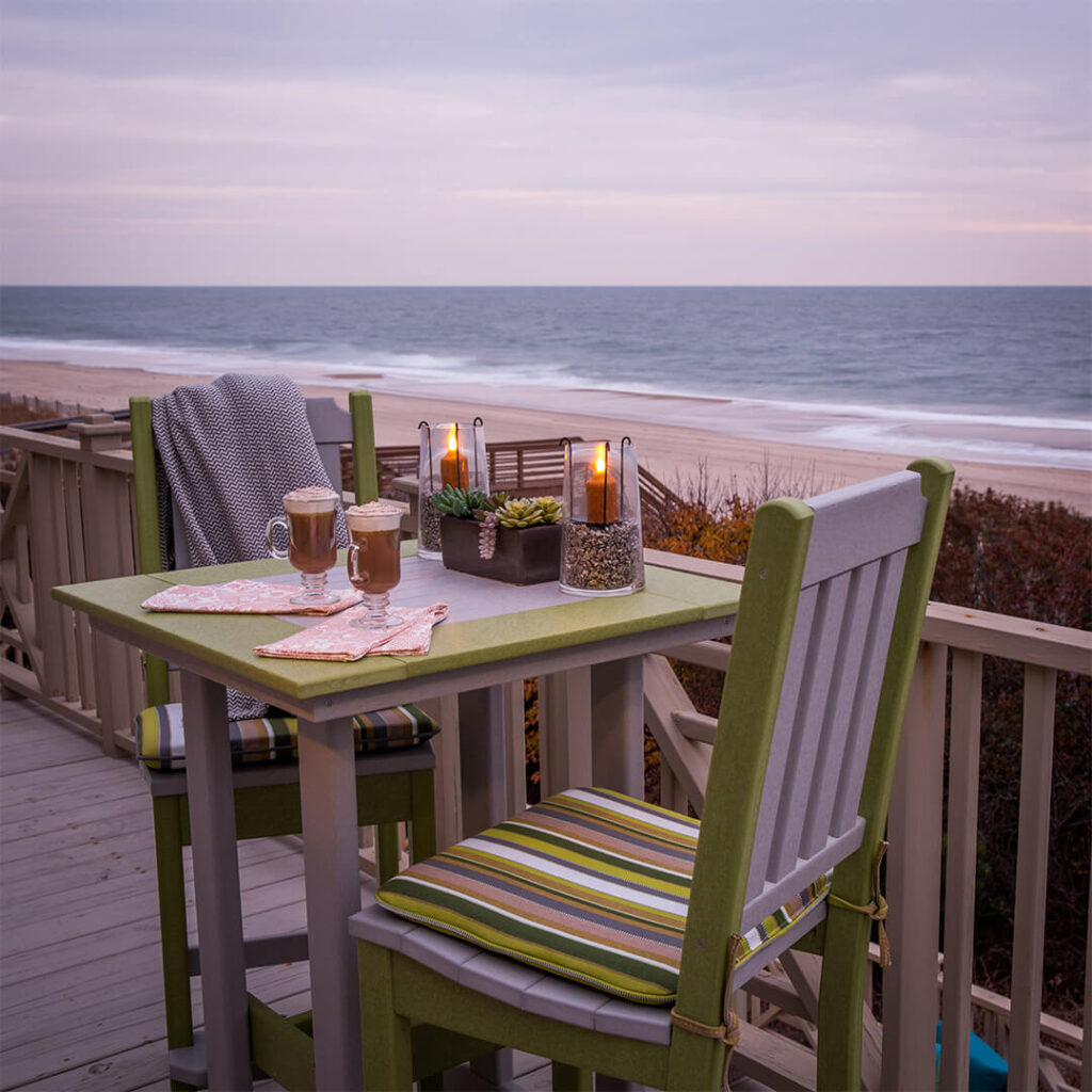A bistro set on a balcony overlooking the beach