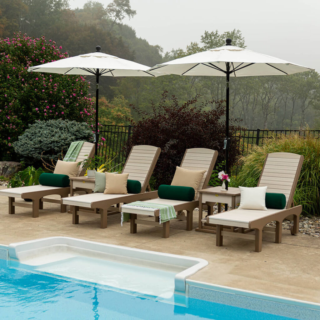 Four lounge chairs next to a pool