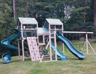 Tan and green vinyl swing set with three slides