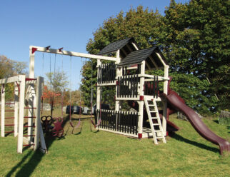 Tan and red vinyl swing set with multiple slides and swings