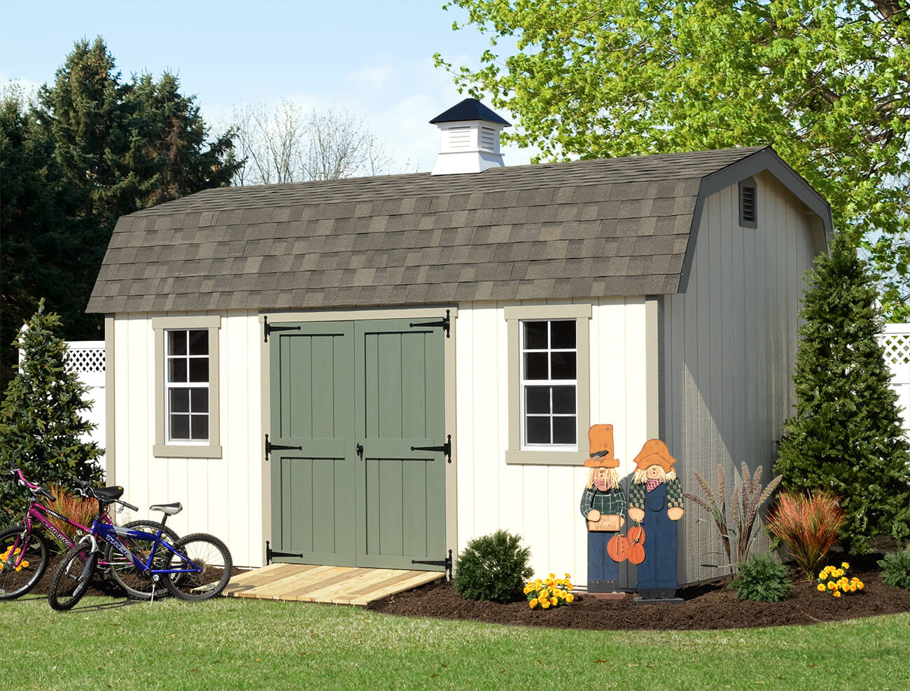 White shed with a green door and bikes sitting outside